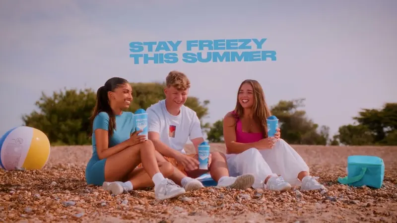 Still from Stay Freezy: three friends on a beach with Fanta Frozen cups.