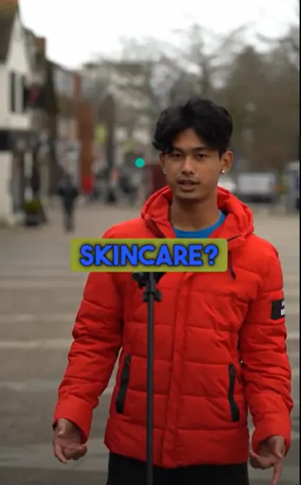 A young man in a red puffer jacket on a high street, captioned Skincare?
