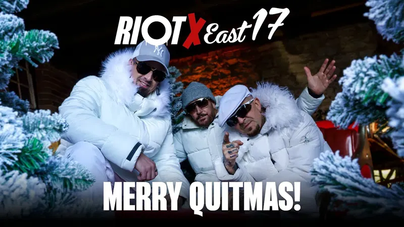 Still from the Merry Quitmas video: East 17 in white coats among Christmas trees, under the Riot x East 17 title.